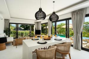 a dining room with a white table and chairs at VIlla Tramonto sunset seaview villa Koh Samui in Koh Samui