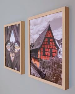 two framed pictures of a building on a wall at Hôtel L'Ours De Mutzig in Mutzig