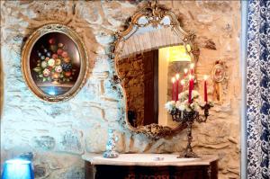 uno specchio su un muro di pietra con un tavolo con candele di Studio with city view and wifi at Piazza Armerina a Piazza Armerina