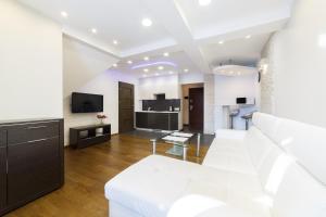 a living room with a white couch and a tv at Apartamenty-Plaza Zakopane in Zakopane