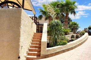 una escalera que conduce a una casa con palmeras en Studio with sea view furnished balcony and wifi at Marsala 1 km away from the beach en Marsala