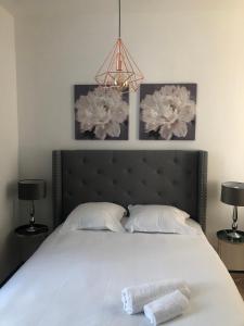 a bedroom with a white bed with two towels on it at Sainte Cécile 2- Studio élégant, idéalement situé in Vichy