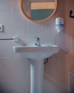 ein Badezimmer mit einem weißen Waschbecken und einem Spiegel in der Unterkunft Barraca Suites in Valencia