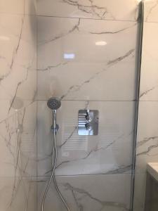 a shower in a bathroom with marble walls at Sainte Cécile 2- Studio élégant, idéalement situé in Vichy +4 photos
