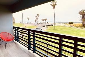 a balcony with a red chair and a view of the ocean at Ocean Villa Inn in San Diego