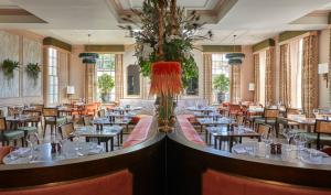 ein Restaurant mit Tischen und Stühlen und eine Vase mit Blumen in der Unterkunft Richmond Hill Hotel in Richmond upon Thames