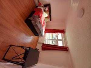 a room with a television and a window at Beautiful 5-Bed House in Dagenham newly Renovated in Dagenham