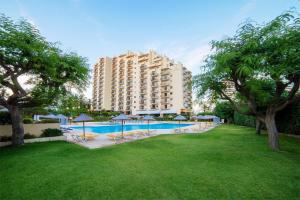 a hotel with a swimming pool and a large building at Seaside Serenity Apartment in Portimão