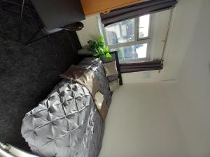 an overhead view of a bed in a room with a window at Beautiful 5-Bed House in Dagenham newly Renovated in Dagenham