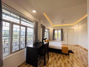 a bedroom with a bed and a desk and windows at 5 Bedroom in Tea Plantation in Munnar