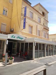 a building with a sign on the front of it at Hotel De La Plage in Valras-Plage