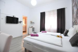 Habitación con 2 camas blancas y TV de pantalla plana. en Green lighthouse rooms en Zadar