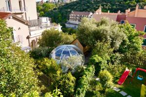 un'immagine di un giardino con una serra di Starsbox con piscina e idromassaggio a Celle Ligure