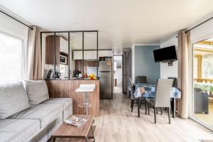 a living room and kitchen with a couch and a table at Mobil-home Saint Jean de Monts in Saint-Jean-de-Monts