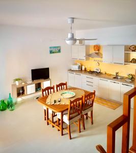 eine Küche und ein Esszimmer mit einem Holztisch und Stühlen in der Unterkunft Casa Vacanza Mare Blu in Villaggio Azzurro