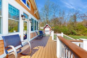 a porch with a bench and a red barn at Rise n Shine in Saugatuck