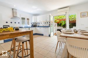 a kitchen with white cabinets and a table and chairs at Villa Oasis by Abahana Villas in Calpe