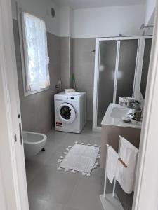 een badkamer met een wasmachine en een wastafel bij Casa vacanze Sofy & Marty in Cattolica