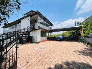 a house with a driveway and a car garage at 5 Bedroom in Tea Plantation in Munnar