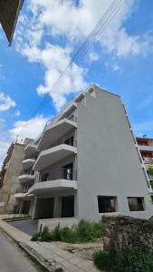 ein weißes Apartmenthaus an der Straßenseite in der Unterkunft Sezame ApartHotel in Ioannina