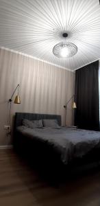 1 dormitorio con 1 cama grande con 2 luces. en Giertmaņa apartamenti, en Liepāja