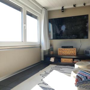 a bedroom with a flat screen tv and two windows at Turpino House in Vilar Torpim