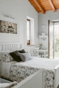 a white bedroom with a bed and a table at LA CASETTA Malpensa Guesthouse in Case Nuove