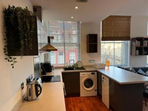 a kitchen with a washer and dryer on a counter at City Centre Apartment Liverpool in Liverpool