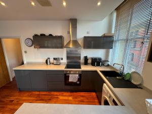 a kitchen with a sink and a stove top oven at City Centre Apartment Liverpool in Liverpool