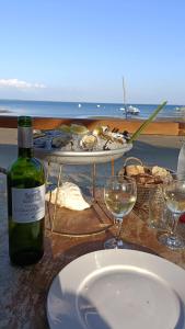ein Tisch mit einem Teller Essen und einer Flasche Wein in der Unterkunft BUNGALOW - Cap Ferret in Lège-Cap-Ferret