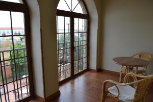 um quarto com grandes janelas e uma mesa e cadeiras em Hotel Rural El Labriego by Vivere Stays em Plasenzuela