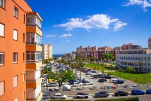 a city with cars parked in a parking lot at Stylish and comfortable one bedroom with sea view in Torremolinos