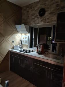 eine Küche mit einem Kochfeld und einem Waschbecken in der Unterkunft Elyam's Home 2 in Douala