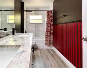 a bathroom with a red shower curtain and a toilet at Sanford's Seahaven in Sanford +18 photos