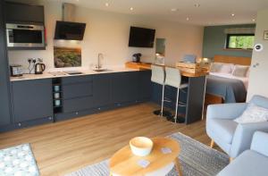 a kitchen and a living room with a couch and a table at The Lodges at Thornbrook in Ingleton 