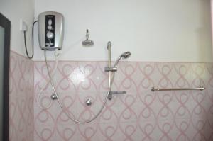 a shower in a bathroom with a phone on the wall at Sunny Lanka Guest House in Matara