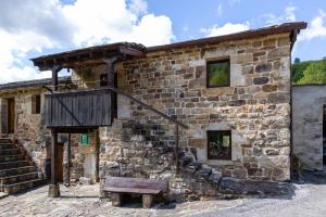 a stone building with a bench in front of it at La Plazuca Cerrucao in Selaya