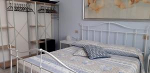 a bedroom with a white bed with a pillow at Phiniscollis B&B in La Caletta