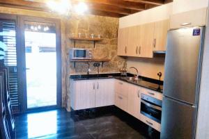 a kitchen with a stainless steel refrigerator and a sink at 4 bedrooms house with sea view enclosed garden and wifi at Cambados Pontevedra 1 km away from the beach in Cambados