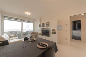 Una cocina y una sala de estar con mesa y sillas. en Torre Mizar 11, en Lido di Jesolo