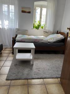 a bedroom with a bed and a white table at Zimmer auf dem Scheuerhof in Wittlich