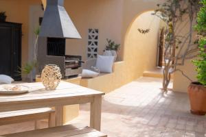 a living room with a table and a fireplace at Bungalows Casa Amarilla in Playa Migjorn