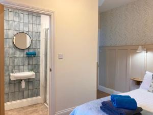 a bedroom with a bed and a sink and a mirror at Laurel Bank House in Penrith +18 photos