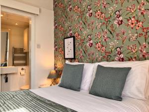 a bedroom with a bed with a floral wallpaper at Laurel Bank House in Penrith