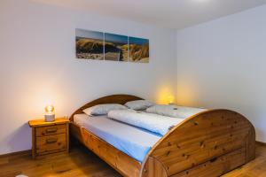 1 dormitorio con 1 cama con marco de madera en Ferienhaus am Staufeneck, en Piding