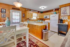- une cuisine avec des placards en bois et un réfrigérateur blanc dans l'établissement Cozy Cabin with Grill and Fire Pit By Dale Hollow Lake, à Frogue
