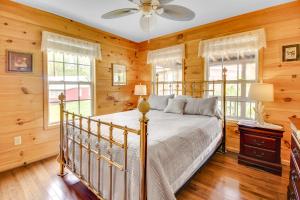 1 dormitorio con 1 cama y 2 ventanas en Cozy Cabin with Grill and Fire Pit By Dale Hollow Lake en Frogue