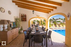 comedor con mesa, sillas y piscina en Villa Serenidad by Abahana Villas, en Benissa
