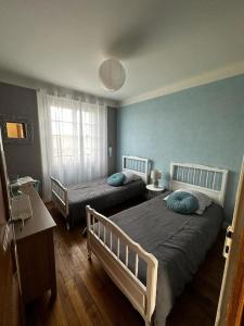 a bedroom with two twin beds and a window at Maison de campagne 5 min A20 in Brive-la-Gaillarde
