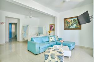 salon z niebieską kanapą i stołem w obiekcie Red House on the beach w mieście Punta Rucia